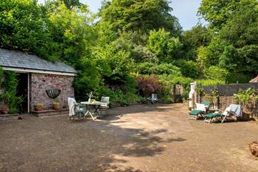 The sunny courtyard is surrounded by lush vegetation