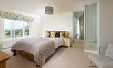 Step into bedroom four, a wonderfully spacious room with a king-size bed and steps leading up to the en suite. - Thumbnail Image