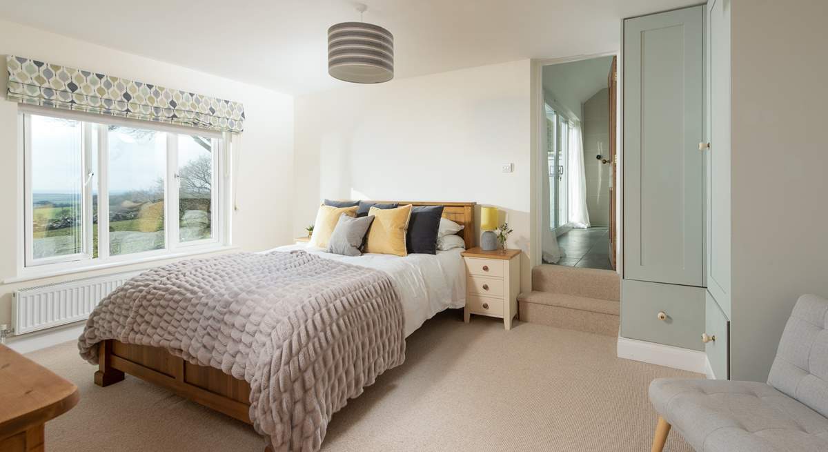 Step into bedroom four, a wonderfully spacious room with a king-size bed and steps leading up to the en suite.