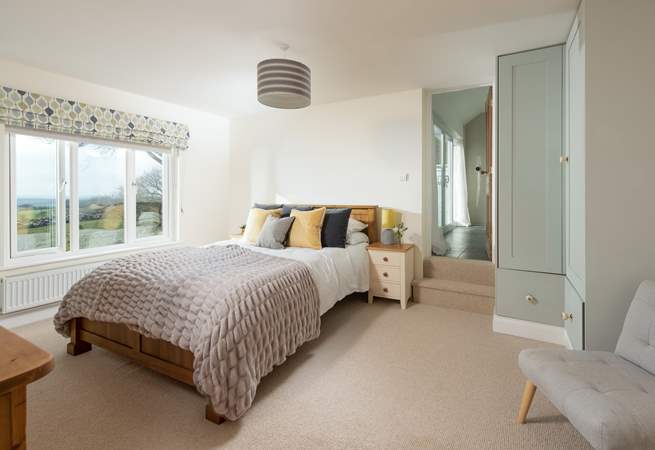 Step into bedroom four, a wonderfully spacious room with a king-size bed and steps leading up to the en suite.