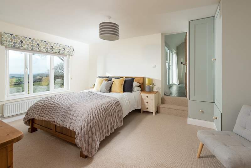 Step into bedroom four, a wonderfully spacious room with a king-size bed and steps leading up to the en suite.