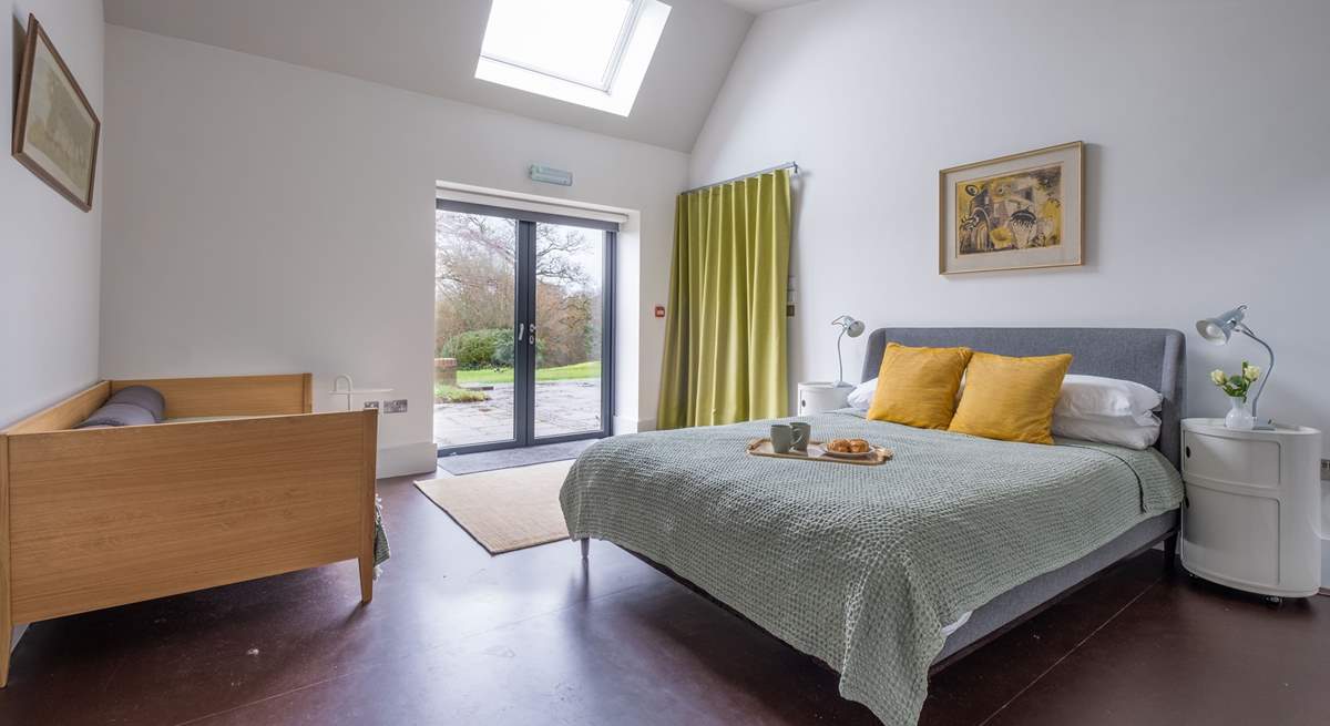 The ground floor bedroom with king-size bed, single bed and double doors that lead to the terrace and garden.