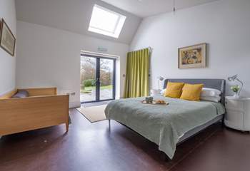 The ground floor bedroom with king-size bed, single bed and double doors that lead to the terrace and garden.