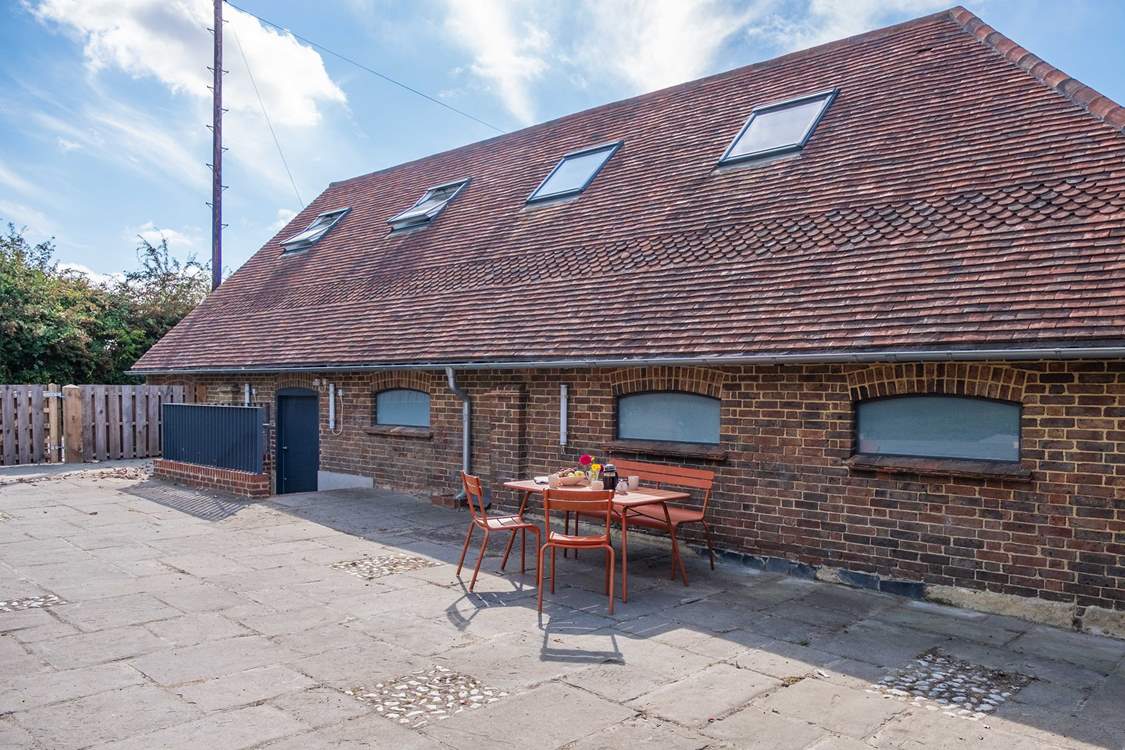A spacious barn in the heart of the Sussex countryside. Steps lead down to the front door.