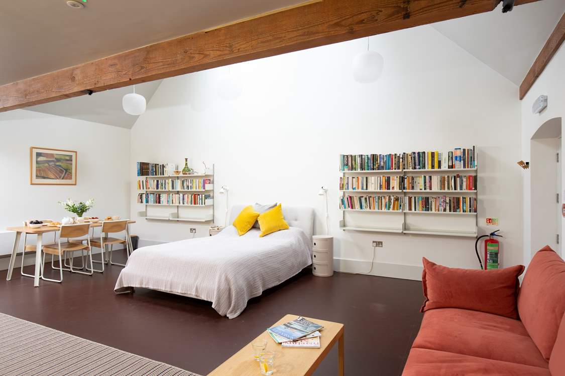 The open plan living area features a king-size double bed as well as a dining-table, sofa and Smart TV.