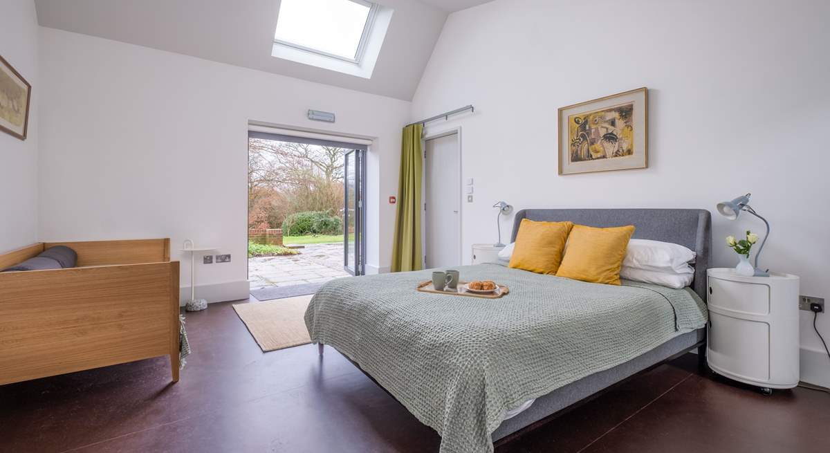 The family bedroom in South Barn has double doors that open onto the terrace and garden.