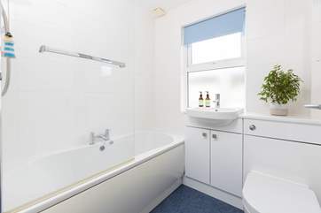 The family bathroom has a bath with shower over.
