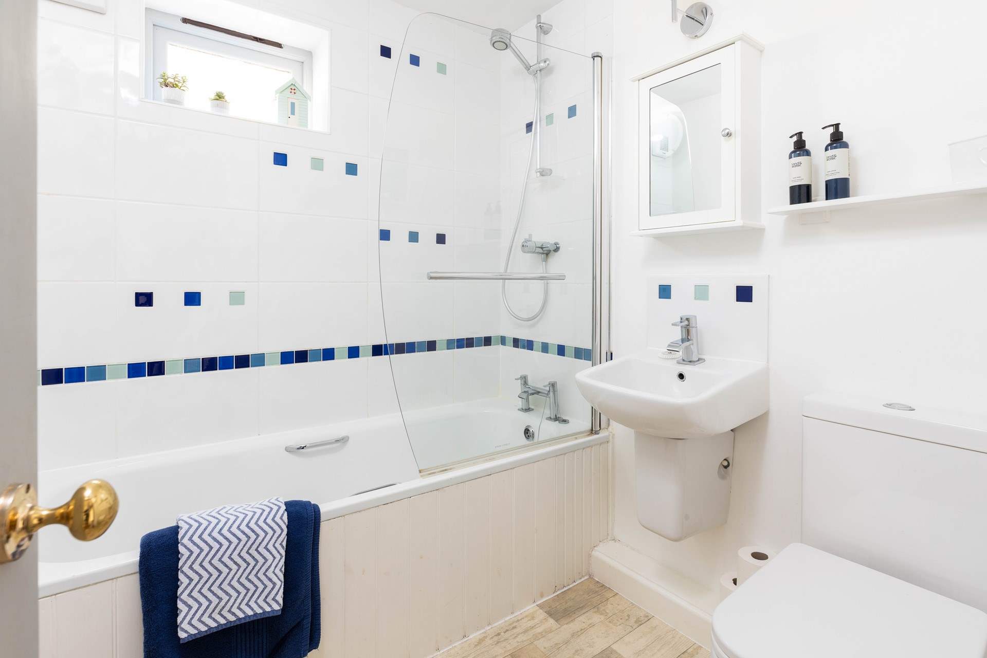 The family bathroom has a bath with shower over.