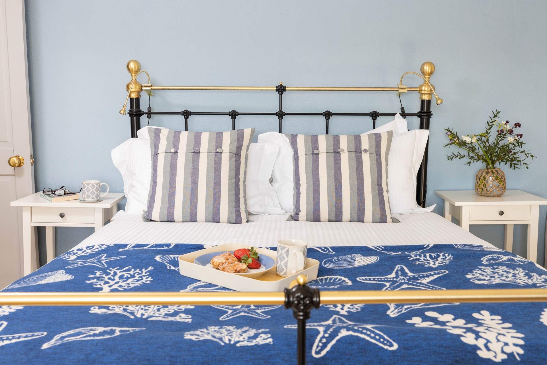 The double bedroom has a lovely iron bedstead and pretty linens.