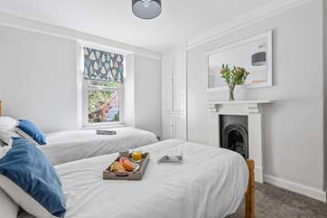 The twin bedroom has a delightful ornamental fireplace.