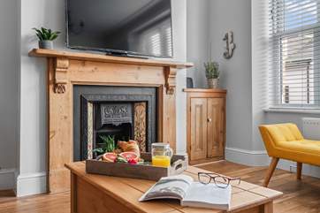The sitting/dining-room has a lovely ornamental fireplace.