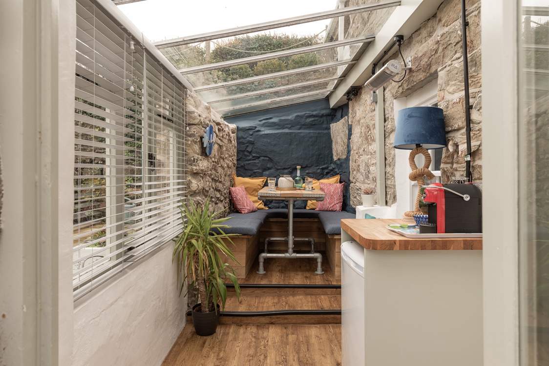 The cute conservatory leads off from the kitchen. Two steps take you up to the table, where you can chat over a coffee or set up a home office work station.