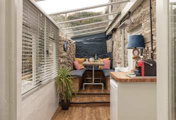 The cute conservatory leads off from the kitchen. Two steps take you up to the table, where you can chat over a coffee or set up a home office work station. 