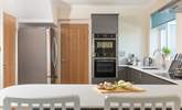 There's a sleek and stylish kitchen along with a utility-room. - Thumbnail Image