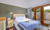 The bright and airy main bedroom has large doors leading to the courtyard garden. - Thumbnail Image