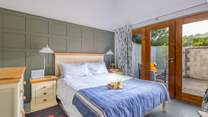 The bright and airy main bedroom has large doors leading to the courtyard garden.