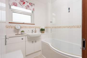 The family bathroom has a small P shaped bath with shower attachment.