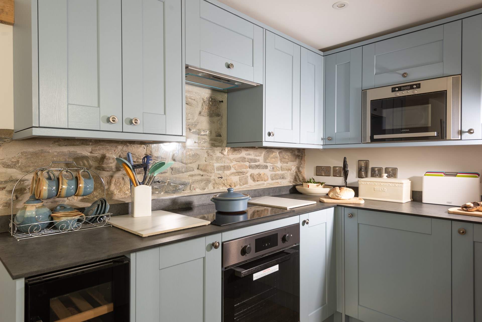 The exposed stonework perfectly complements the soft tones of the kitchen.