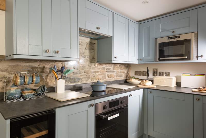 The exposed stonework perfectly complements the soft tones of the kitchen.