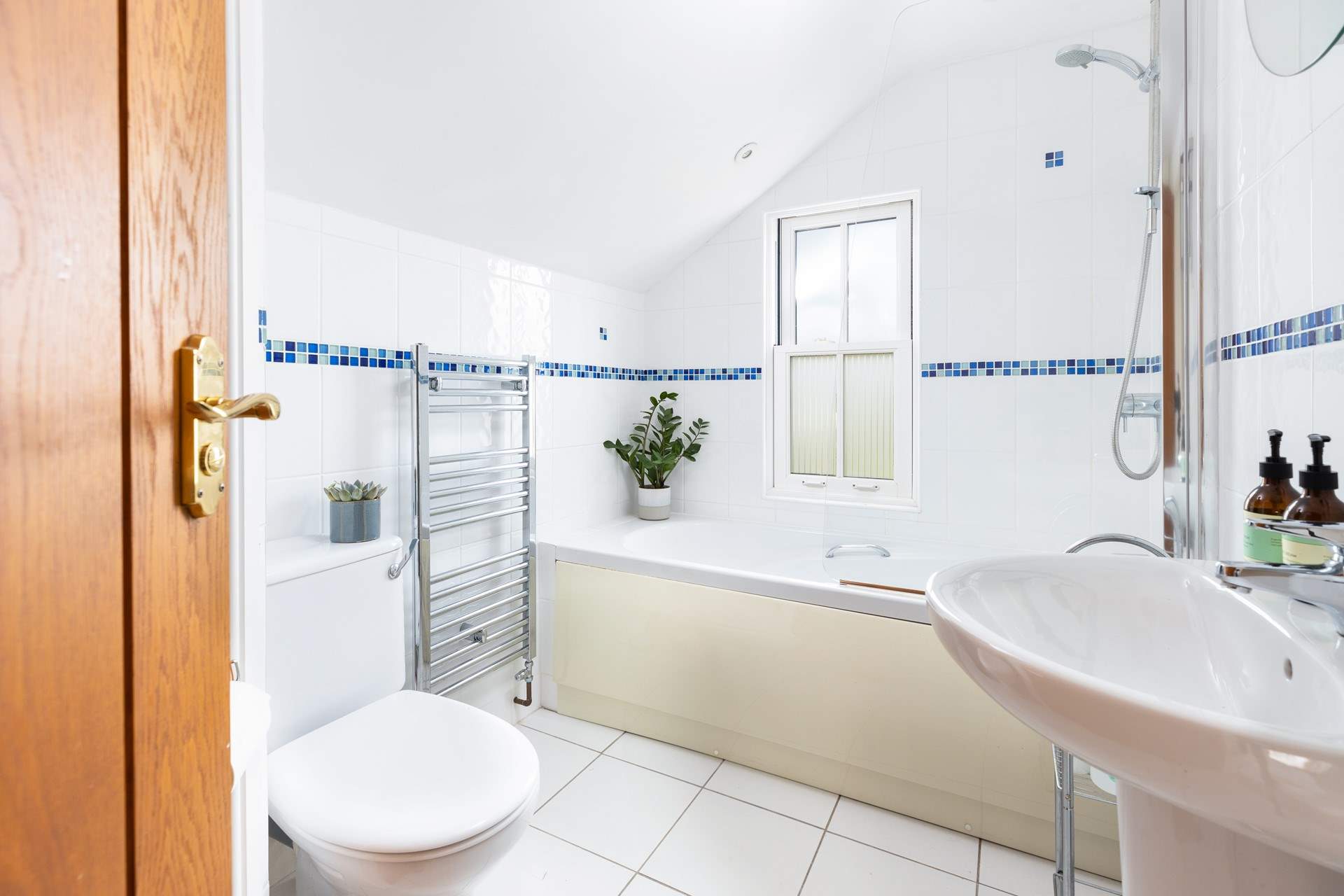 The family bathroom has a bath with shower over.