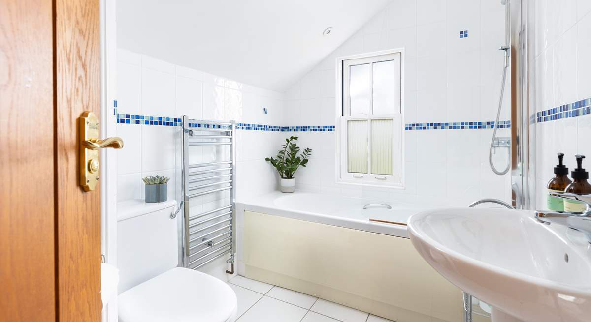 The family bathroom has a bath with shower over.