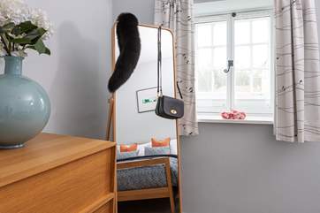 The hanging rail is cleverly hidden behind the mirror