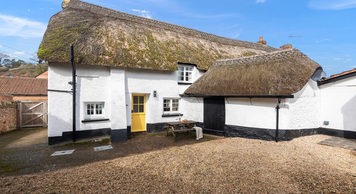 The beautiful back of the house, with parking and a picnic table.