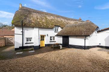The beautiful back of the house, with parking and a picnic table.