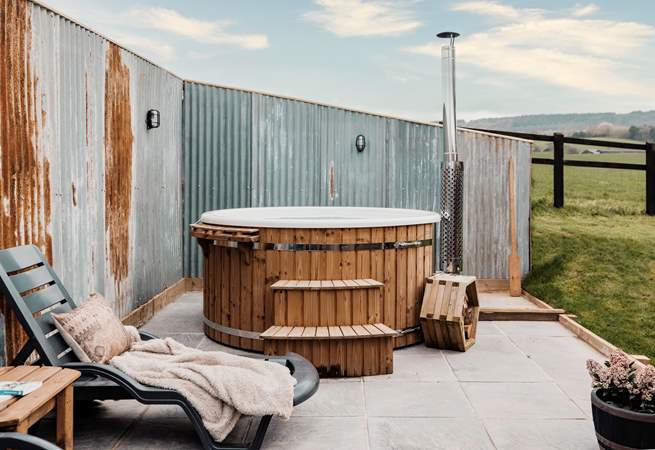 The luxurious secluded hot tub boasts tranquil views of sweeping countryside vistas.