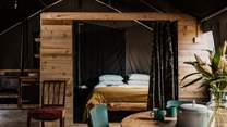 The cabin-style bedroom is complete with a sumptuous double bed, adorned with soft linens. 