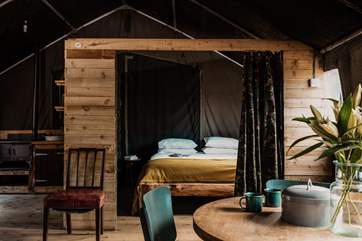 The cabin-style bedroom is complete with a sumptuous double bed, adorned with soft linens.