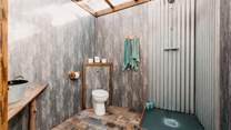 With a transparent roof which makes it feel as though you are showering in the wilderness. 