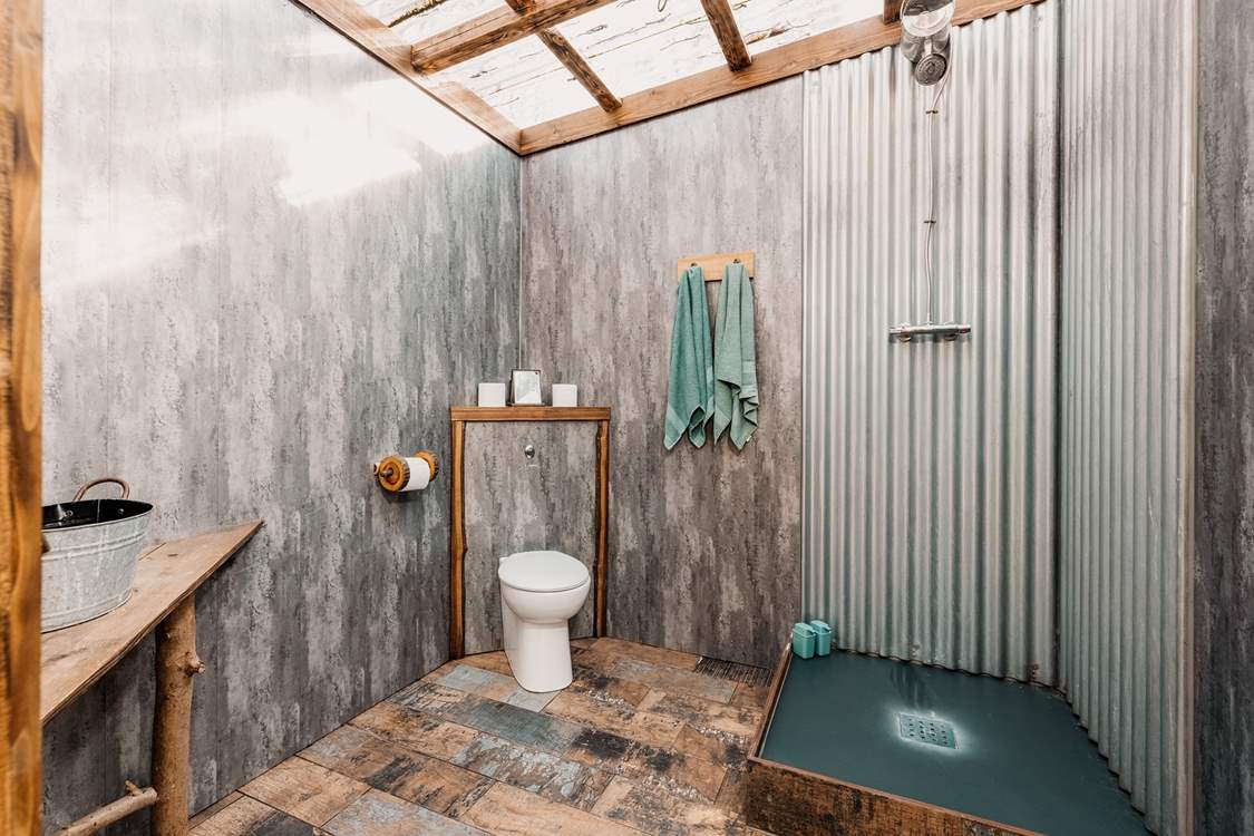 With a transparent roof which makes it feel as though you are showering in the wilderness.