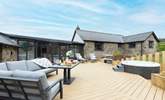 The large sunny decking area, complete with bubbly hot tub, beckons you to relax outside to the front of the house. - Thumbnail Image