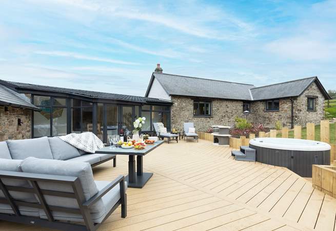 The large sunny decking area, complete with bubbly hot tub, beckons you to relax outside to the front of the house.