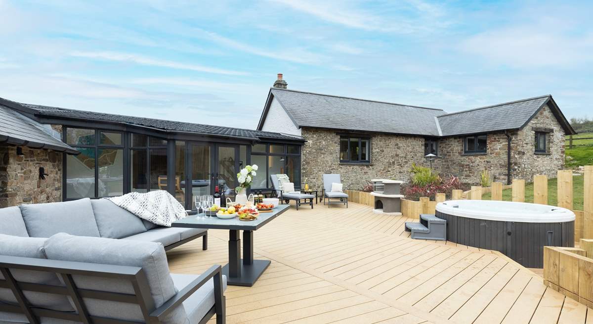 The large sunny decking area, complete with bubbly hot tub, beckons you to relax outside to the front of the house.