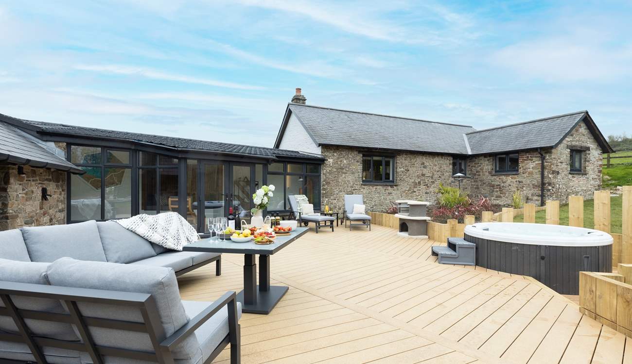 The large sunny decking area, complete with bubbly hot tub, beckons you to relax outside to the front of the house.