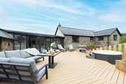 The large sunny decking area, complete with bubbly hot tub, beckons you to relax outside to the front of the house.