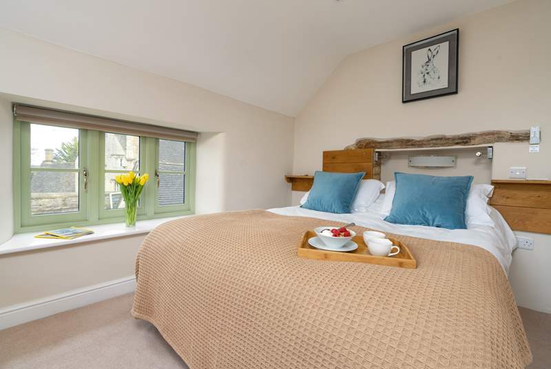 The bedroom offers both comfort and pretty views of the Cotswold rooftops.