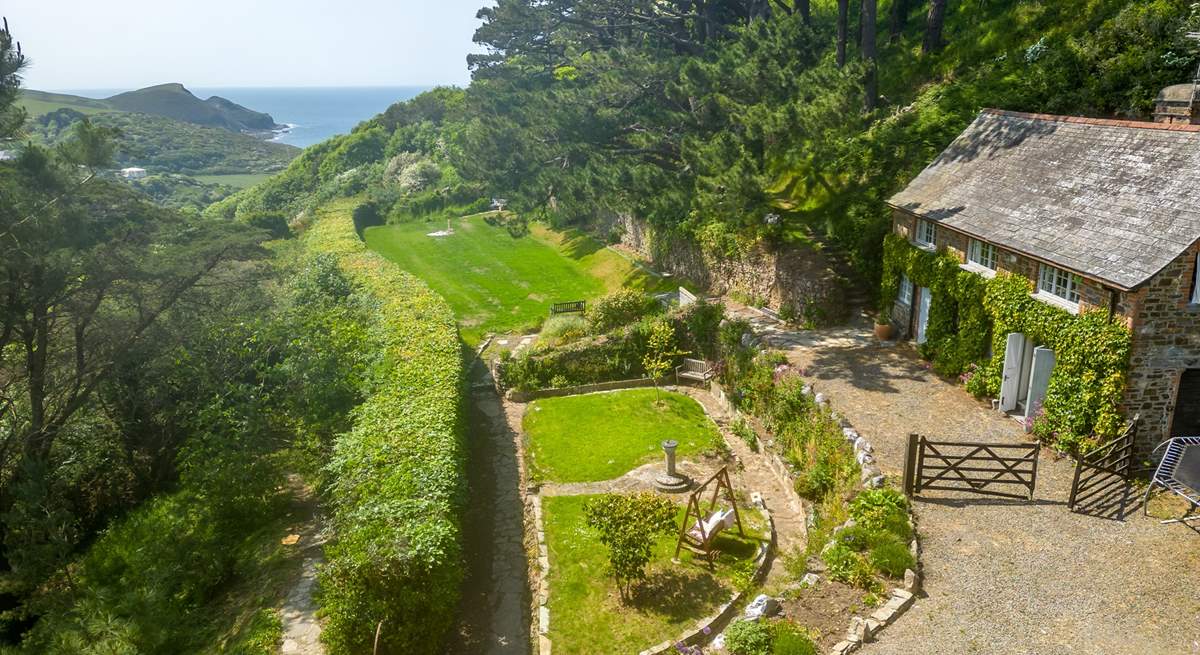 Views across the garden out to the coast (please note, the building on the right is secured and used for storage purposes only during the 2023 season however it is anticipated that it will be in use as a dwelling in 2024). 