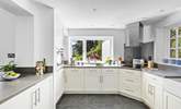 At the end of the open plan living/dining space the fully equipped kitchen can be found with views out to the coast across the garden. - Thumbnail Image