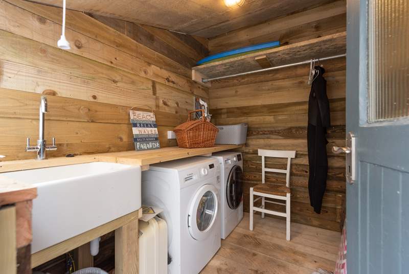 The utility-room has a washing machine and tumble-drier.