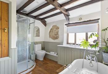 The gorgeous bathroom has a fabulous freestanding roll-top bath and a separate shower.