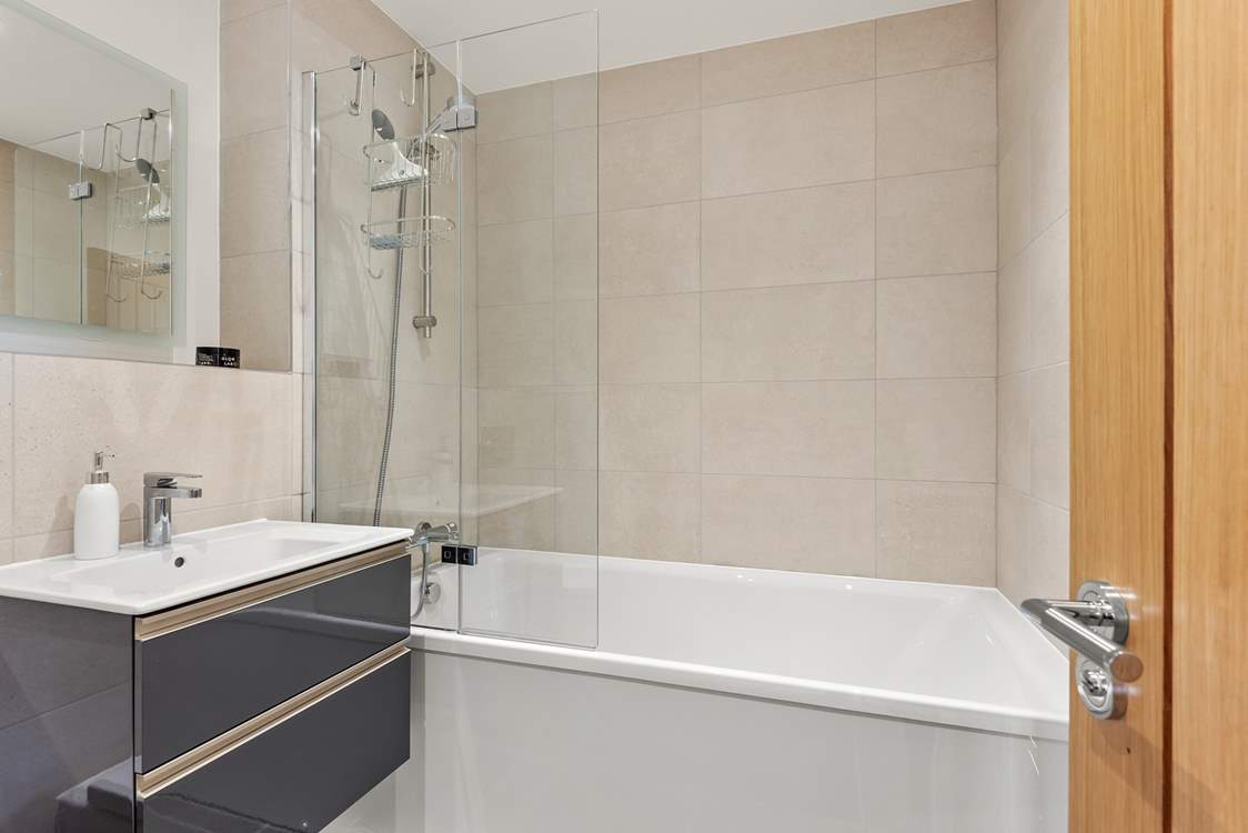 The super family bathroom has a bath with shower overhead.