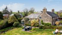 This stunning home is surrounded by wonderful gardens. 