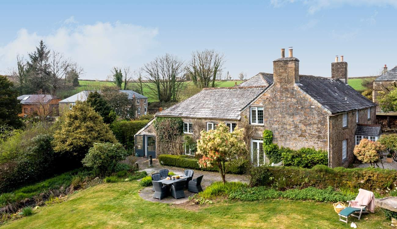 This stunning home is surrounded by wonderful gardens. 