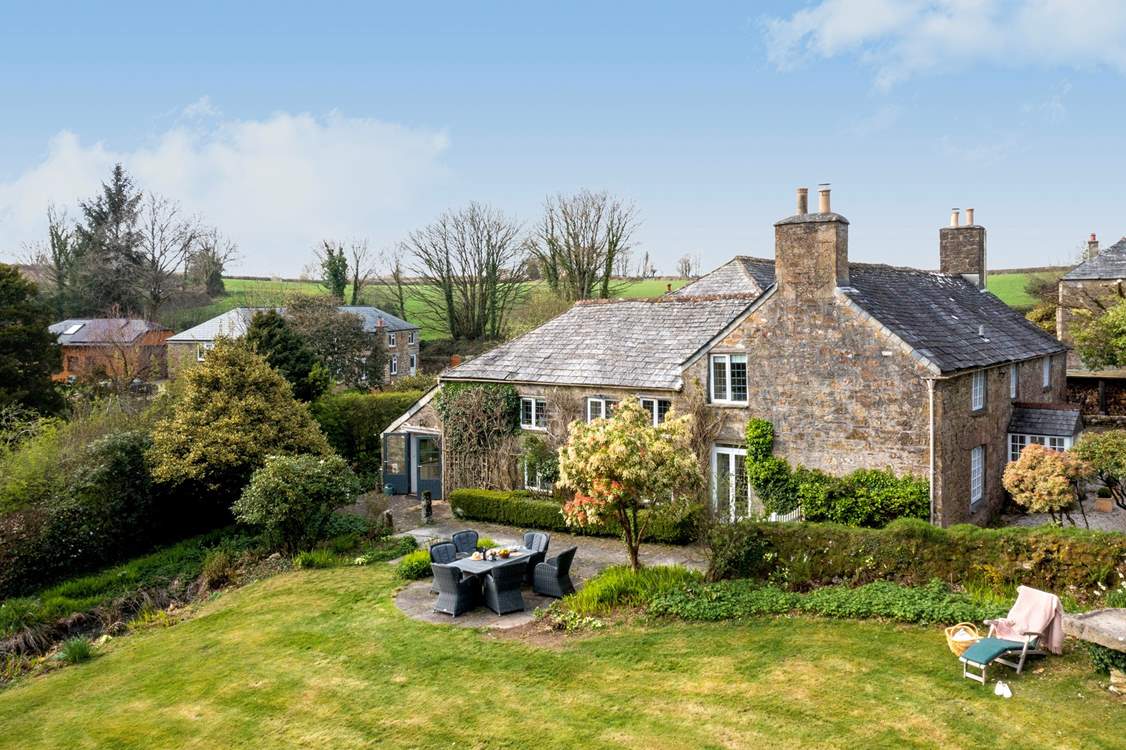 This stunning home is surrounded by wonderful gardens.