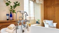 The family bathroom has a bath with hand shower attachment.