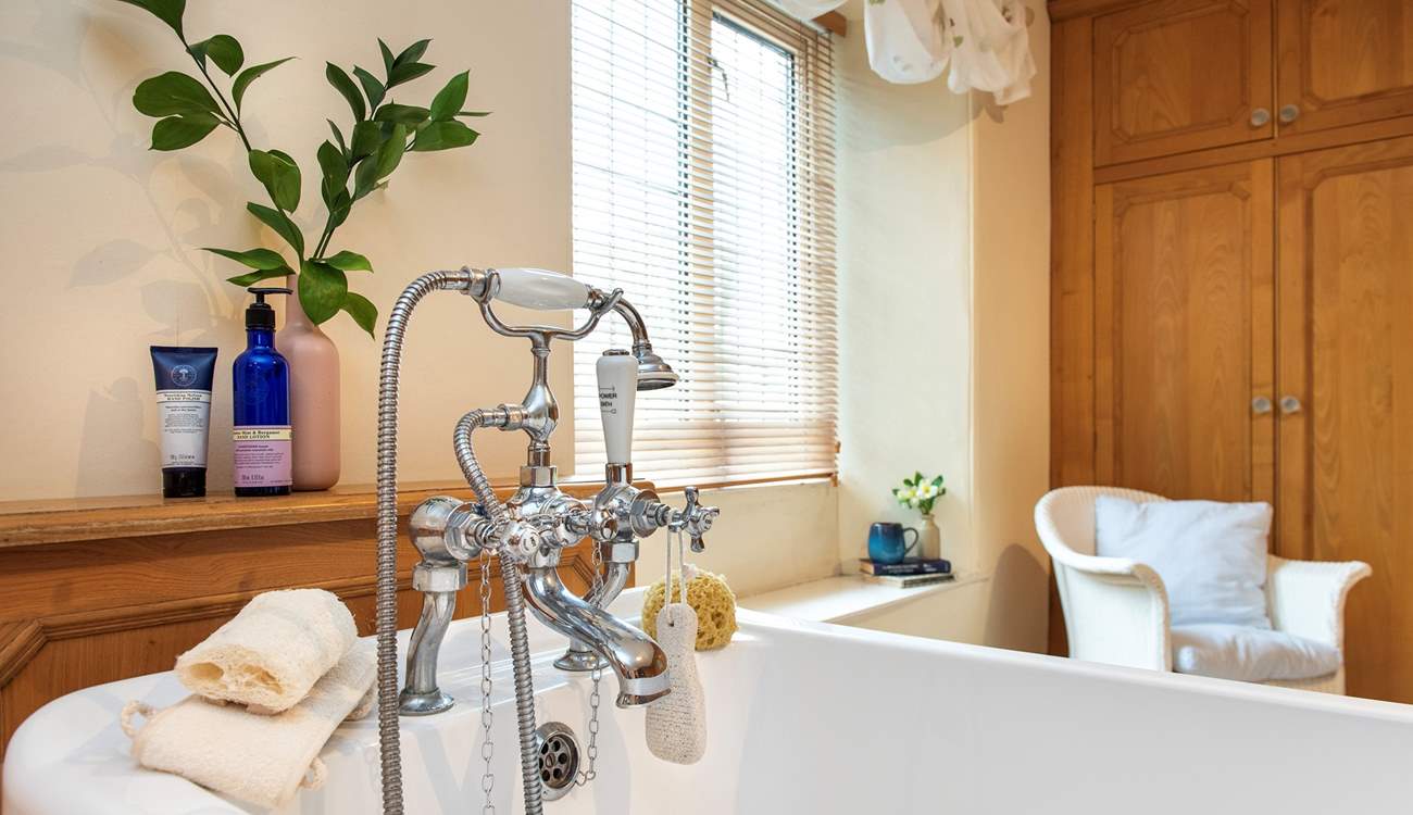 The family bathroom has a bath with hand shower attachment.