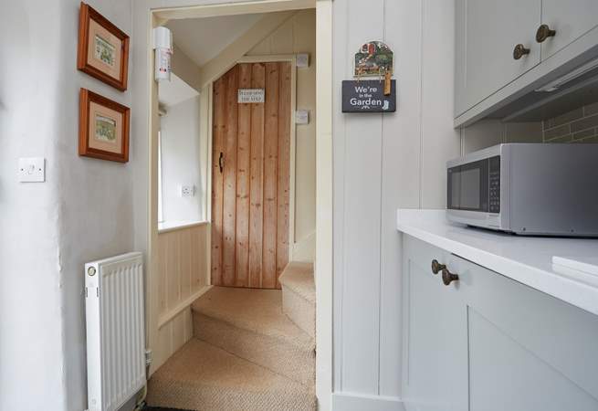 Beyond the kitchen, two steps up to the bathroom and the cottage staircase.
